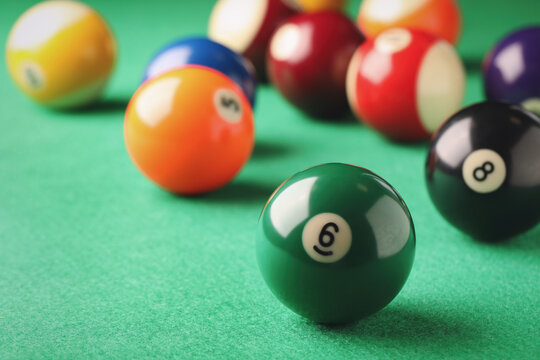 Billiard ball with number 6 on green table, closeup. Space for text