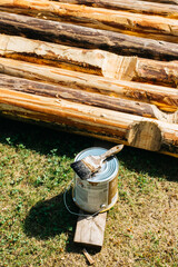 Paintbrush and wooden logs for a DIY cabin project