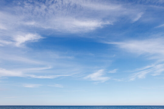 Beautiful blue sky over the sea with translucent, white, Cirrus clouds