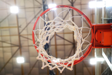 Fototapeta na wymiar Close-up of the basketball hoop in the gym. Selective focus in the center of the photo