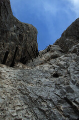 Tritteisen und Drahtseilsicherung auf einem Klettersteig in einer Felswand