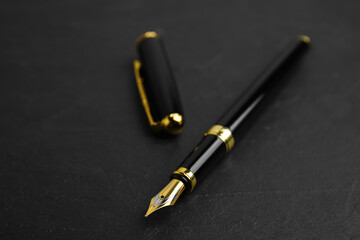Beautiful fountain pen with ornate nib on black table, closeup