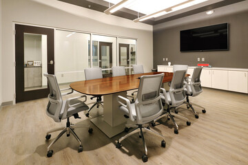 Fototapeta na wymiar Conference room in business with wooden table, office chairs, and monitor