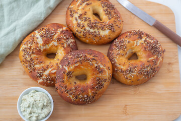 Freshly baked whole grain bagels. heap of fresh baked bagels on a table