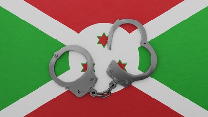 A half opened steel handcuff in center on top of the national flag of Burundi