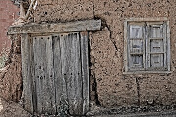 fachada de casa de barro con ventana y puerta de madera antigua