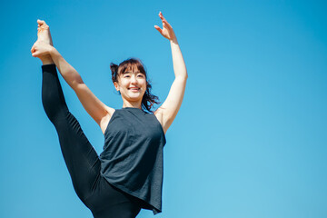 屋外で開脚ストレッチする女性
