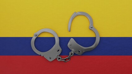 A half opened steel handcuff in center on top of the national flag of Colombia