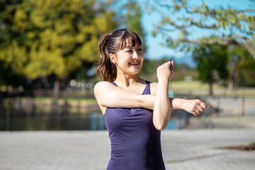 公園で準備運動する女性（腕）
