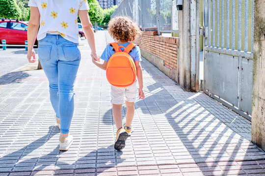 Hispanic Mother And Son Walk Hand In Hand On The Way To School