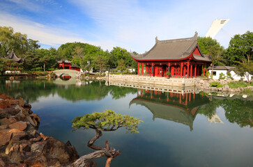 Naklejka premium Garden in Montreal and Chinese architecture reflected on the lake, Quebec