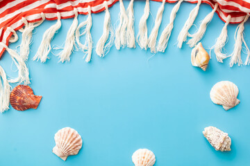 summer background of pareos with fringe, seashells on blue backdrop
