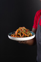 african guy holding a plate of oriental food