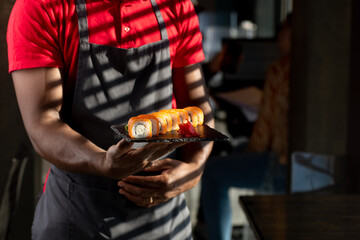 african guy holding a plate with roll