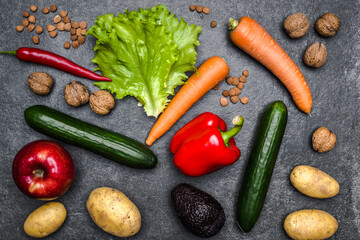 Healthy food background. Healthy vegetarian food. Vegetables and fruits on black stone. Clean vegetarian eating concept.