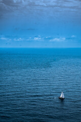 Obraz na płótnie Canvas A sailboat sails the Mediterranean near the Nao Cape in Javea, Spain