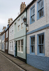 Fototapeta premium Generic traditional english village street with pastel painted houses.