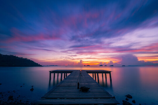 Long exposure landscape ,Pier of wood with a beautiful twilight sunset sky background, Dramatic purple sky , at Phangka beach koh samui thailand © kongkiat chairat