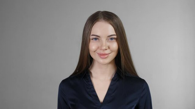Beautiful woman with long smoth brunette hair looking camera close up