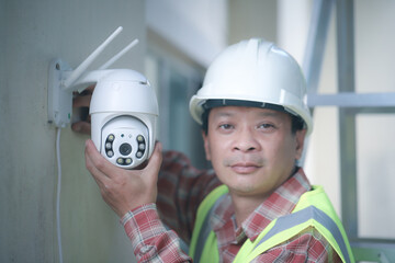 Technician installing IP  wireless CCTV camera installing security equipment water proof cover to...