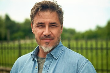 Portrait of mature age, middle age, mid adult man in 50s, happy confident smile, outdoor at home in garden.