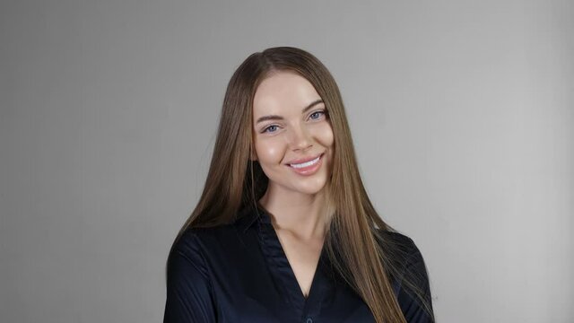 Beautiful woman with long smoth brunette hair looking camera close up