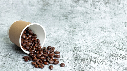 Coffee beans in a paper cup on marble background and have Free space for text menu, front view
