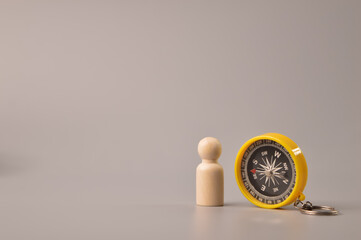 Wooden doll figure and magnetic compass. Symbol of strategy and future vision