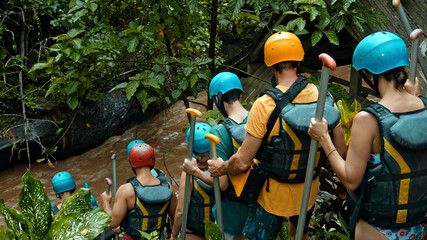 People descending stairs in black protective jackets with yellow lines and protective helmets for...