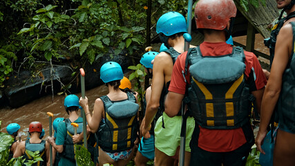 People descending stairs in black protective jackets with yellow lines and protective helmets for...