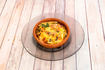Vegetarian lasagna with béchamel gratin and slices of Italian pasta in a clay pot