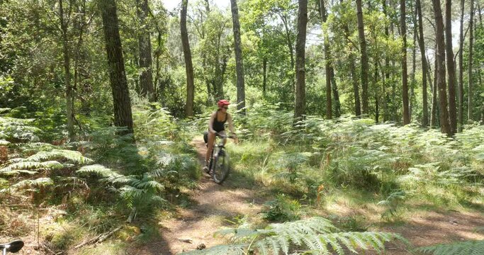 beautiful young woman mountain biking in the forest