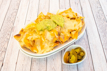 Corn nachos recipe with guacamole, melted cheese and jalapeno slices