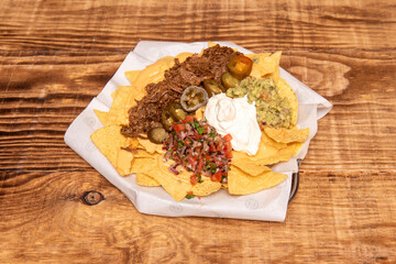 corn nachos with jalapenos, guacamole, gratin cheddar cheese, cream cheese, shredded meat