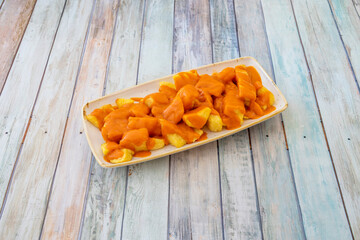 Rectangular tray of typical chips with Madrid brava sauce