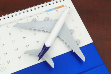 Flight schedule and planning travel concept. Airplane model on calendar page.