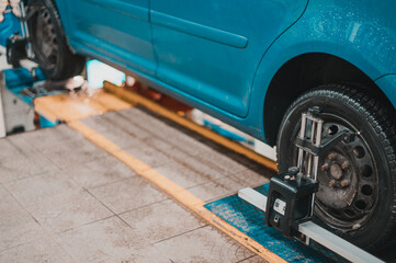 Close-up of a tire clamped by a leveler that passes the automatic alignment of the wheels in the...