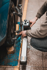 Close-up of a tire clamped by a leveler that passes the automatic alignment of the wheels in the...