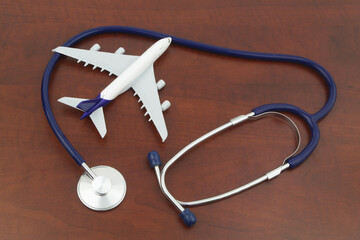 Airplane model and stethoscope, top view. Travel insurance, medical tourism concept.	