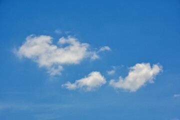 Beautiful cumulus clouds against the blue daytime sky.
