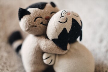 Zwei Stoffkatzen umarmen sich