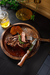 medium rare Steak on bone Veal rib with potato on a wooden plate