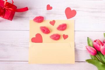 Marmalade in the form of pink lips and red hearts on a yellow card. Flat lay.