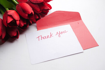 thank you message, envelope and red tulip flower on white background