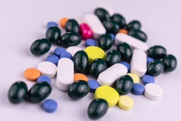 Many multi-colored pills on a white background.
Close-up.