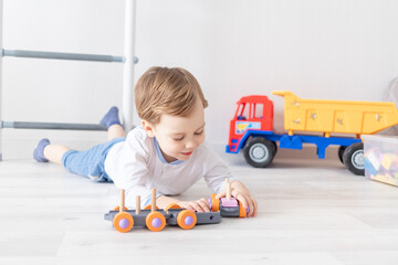 baby boy playing with wooden toys at home on the floor