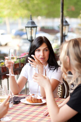 Women at cafe drinking coffee and talking. Communication and friendship concept.