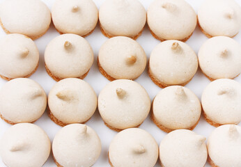 Fototapeta na wymiar small meringue cookies, arranged in row, homemade cakes