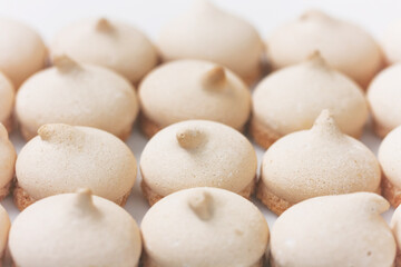 Fototapeta na wymiar small meringue cookies, arranged in row, selective focus