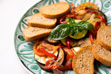 Baked vegetables with toasts. Italian dish.